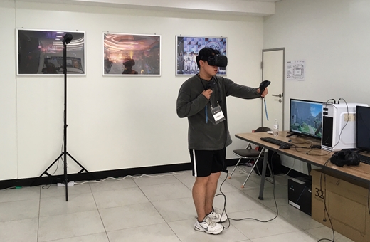 14일 '하이콘핵스' 행사장 한켠에 마련된 VR(가상현실) 게임기 이용 방법을 설명중인 한 관계자. ⓒEBN
