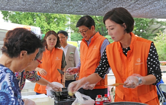 박윤식 한화손해보험 대표이사(오른쪽에서 두 번째)가 18일 서울시 동작구 대방종합사회복지관에서 지역내 저소득층 노인을 위해 '사랑의 밥차' 무료 급식 나눔 행사를 펼치고 있다.ⓒ한화손해보험