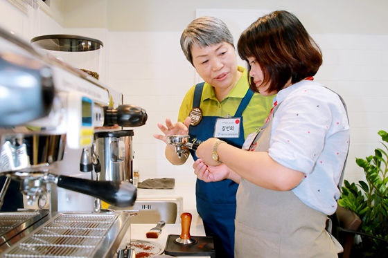 서울시 어르신 취업지원센터에서 다문화가정 여성들이 시니어 교육 강사들의 도움을 받아가며 커피 교육을 수강하고 있다.ⓒ우리카드