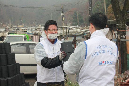 남양유업 대리점주와 직원이 연탄 나르기 봉사를 하고 있다.