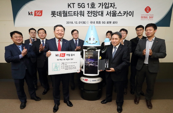 1일 KT 5G 머신 1호 가입자인 인공지능 로봇 '로타'가 KT 관계자들과 함께 환호하고 있다.ⓒKT