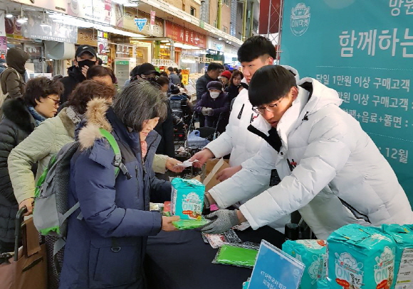 KT가 지난 15일 서울 마포구 망원시장에서 소상공인 지원 온(ON)마켓 행사를 진행하며 시장 방문 고객들에게 장바구니와 온쫄면, 온음료 등을 나눠주고 있다.ⓒKT