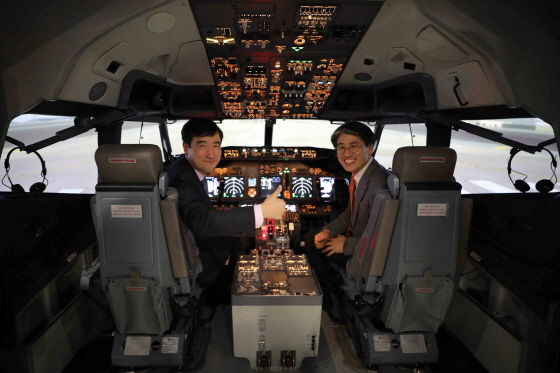 지난 19일 김포국제공항에서 진행된 시뮬레이터 도입행사에서 제주항공 이석주사장(사진 왼쪽)과 김재천부사장이 시뮬레이터 안에서 기념촬영을 하고 있다.ⓒ제주항공