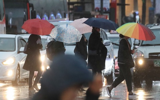 비가 내린 지난 15일 오후 서울 광화문역 인근에서 시민들이 길을 건너고 있다.ⓒ연합뉴스