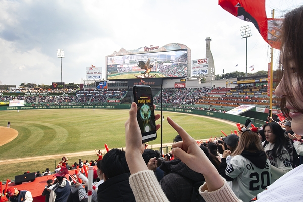 23일 인천 SK행복드림구장에서 열린 프로야구 개막전을 찾은 야구팬이 SK텔레콤의 AR 비룡 이벤트에 참여하고 있다. ⓒSK텔레콤