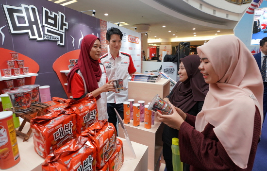 말레이시아 쿠알라룸프라 한 쇼핑몰 내에 위치한 대박라면 홍보부스에서 현지 소비자들이 대박라면에 대한 설명을 듣고 있다.