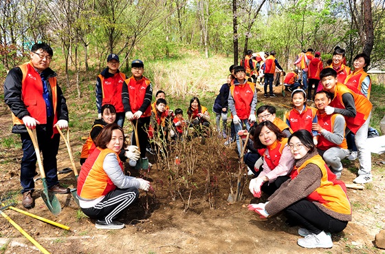 SK건설 임직원 가족봉사단이 화단에 나무를 심고 기념촬영을 하고 있다. ⓒSK건설