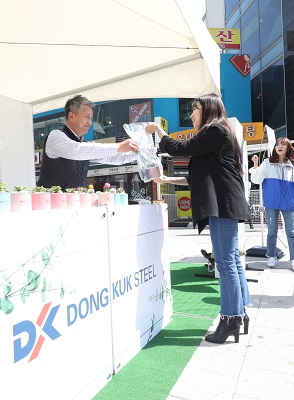 장세욱 동국제강 부회장(왼쪽)이 15일 서울 마포에서 한 시민에게 철로 만든 미니 화분을 나눠주고 있다.ⓒ동국제강