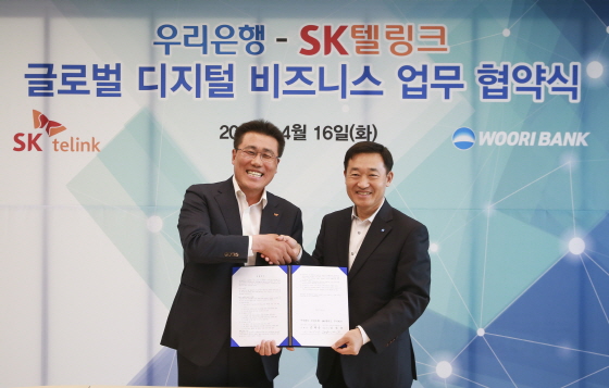 SK텔링크 김선중 대표이사(왼쪽)와 정채봉 우리은행 영업부문장이 4월 16일 우리은행 본점에서 '글로벌 디지털 비즈니스 협력 MOU'를 체결했다.