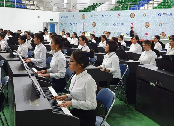 지털피아노 기증식 행사에 참석한 우즈베키스탄 학생들이 한국의 졸업식 노래를 연주하는 모습ⓒ부영