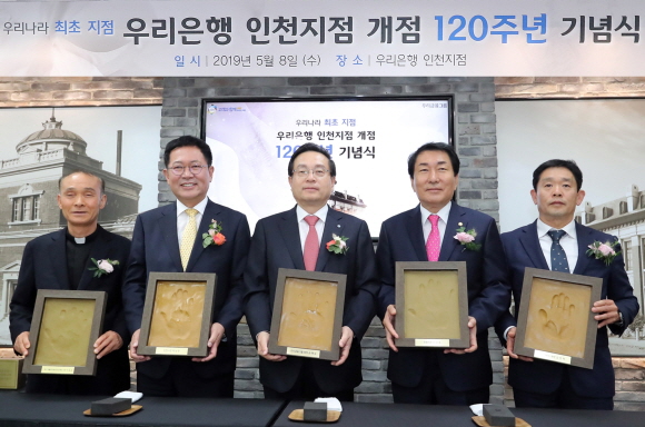 지난 8일 인천지점 개점 120주년 기념행사에 참석한 손태승 우리금융그룹 회장(사진 가운데)이 박남춘 인천시장(사진 왼쪽에서 두번째) 등 관계자들과 함께 핸드프린팅을 들고 기념촬영을 하고 있다.ⓒ우리은행