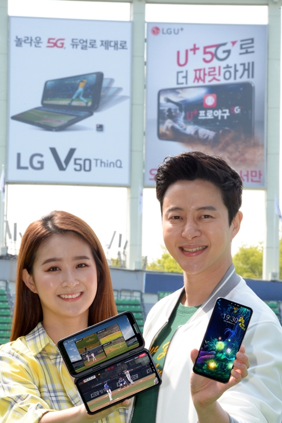 LG전자가 지난 10일 국내 출시한 5G 스마트폰 LG V50 씽큐를 알리기 위한 마케팅 활동에 가속도를 낸다. LG전자 모델들이 서울 송파구 소재 잠실야구장 외야 조명탑에 설치된 옥외광고를 배경으로 LG V50 씽큐를 소개하고 있다.ⓒLG전자