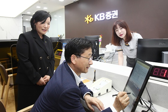 27일 KB증권 박정림 사장(왼쪽)과 한국주택금융공사 이정환 사장(가운데)이 KB증권 여의도 영업부를 방문하여 디지털창구를 통해 MBS 매수를 하고 있다. ⓒKB증권
