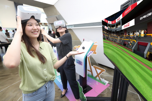 KT 모델들이 기가라이브TV를 이용해 VR 스포츠 게임을 즐기는 동시에 게임 속 경기장 전광판과 배너를 통해 노출되고 있는 VR 광고를 체험하고 있다.ⓒKT
