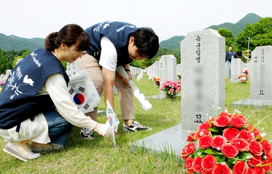 아프로서비스그룹 임직원들이 국립대전현충원에서 묘역정화 활동을 하고 있다.ⓒOK저축은행