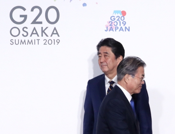문재인 대통령이 지난달 28일 오전 인텍스 오사카에서 열린 G20 정상회의 공식환영식에서 의장국인 일본 아베 신조 총리와 악수한 뒤 이동하고 있다. ⓒ연합