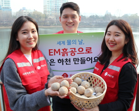 롯데주류 신입사원 및 멘토 30여명이 서울 강남구 양재천에서 수질정화용 미생물균과 황토를 섞어 만든 ‘EM(Effective Micro-organisms)흙공’을 던지고 기념촬영을 하고 있다.

