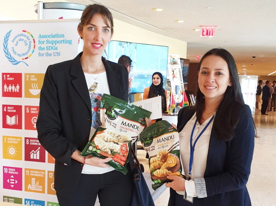 UN지원SDGs협회가 유엔 본부 1층에 글로벌 지속가능기업 모델과 글로벌 주요 리더들의 지속가능 사례를 전시한 가운데, CJ제일제당 부스를 찾은 관계자들이 비비고 만두 제품에 관심을 보이고 있다.