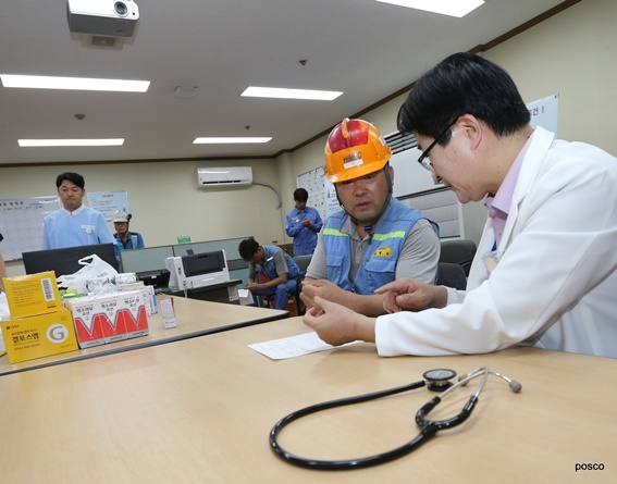 포항제철소 고로 방문진료에서 김창우 건강증진섹션 의사(사진 오른쪽)가 현장 직원에게 진료 내용을 설명하고 있다.ⓒ포스코