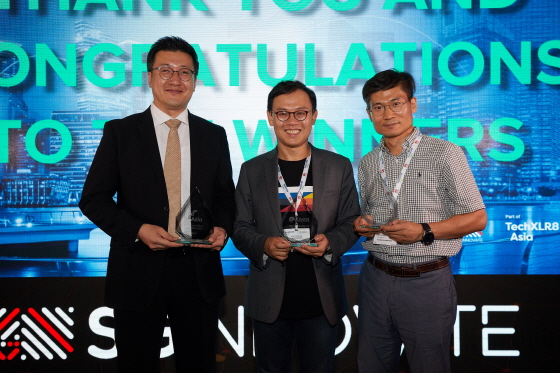 SK텔레콤은 11일 싱가포르에서 열린 'TechXLR8 Asia' 어워드에서 '5G 혁신 기술' 등 총 3개 부문에서 수상했다. 어워드에 참석한 SK텔레콤 이강원 클라우드랩스장(가운데), 류탁기 AN개발팀장(왼쪽)과 구성원의 모습.