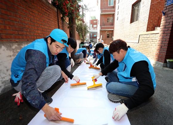 지난 15일 서울 마포구에서 대우건설 직원들이 노후주택에 도배할 벽지에 풀을 바르고 있다.ⓒ대우건설