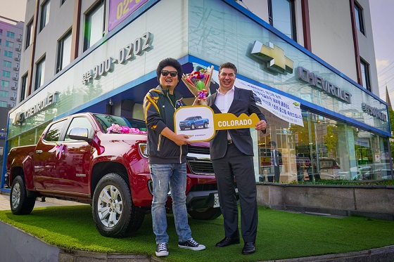 1호차 구매 고객인 개그맨 윤택씨(왼쪽)와 한국지엠 카허 카젬 사장이 차량을 전달하고 축하하는 모습. ⓒ한국지엠