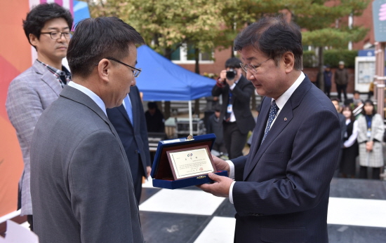 SK바이오사이언스 이상균 L하우스 공장장(왼쪽)이 ‘안동종합사회복지관 25주년 기념식’에서 사회공헌 활동의 공로를 인정받아 권영세 안동시장으로부터 상패를 받고 있다.