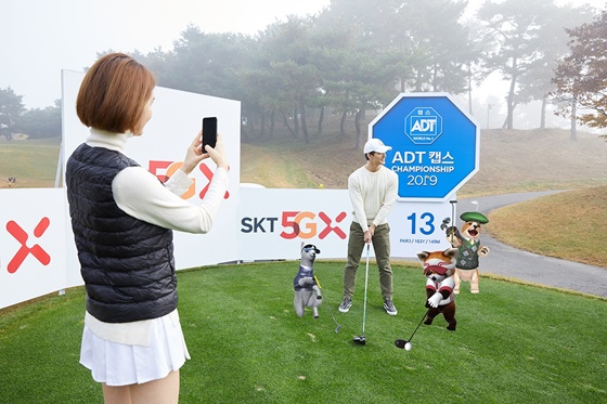 SK텔레콤 홍보 모델들이 천안 우정힐스CC의 ‘SKT 5GX 시그니처홀(13번 홀)’에서 ‘점프 AR 동물원 골프’로 AR 동물들과 사진을 찍고 있다. ⓒSKT