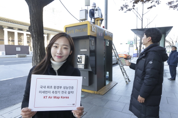 서울 광화문에 교체 설치된 측정소 앞에서 KT 홍보모델이 에어맵코리아를 홍보하고 있다.ⓒKT