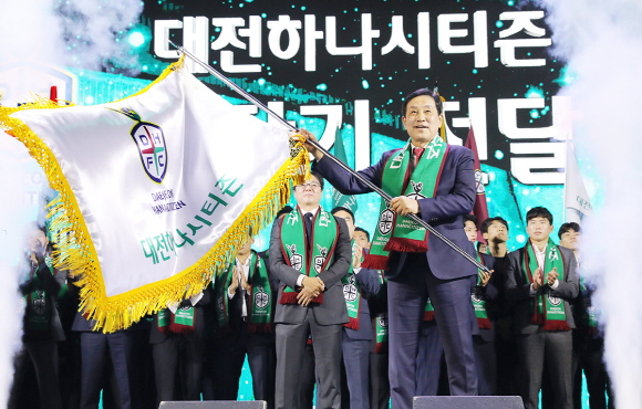 지난 4일 대전 충무실내체육관에서 열린 대전하나시티즌 창단식에 참석한 김정태 하나금융그룹 회장이 구단기를 흔들고 있다.ⓒ하나금융그룹