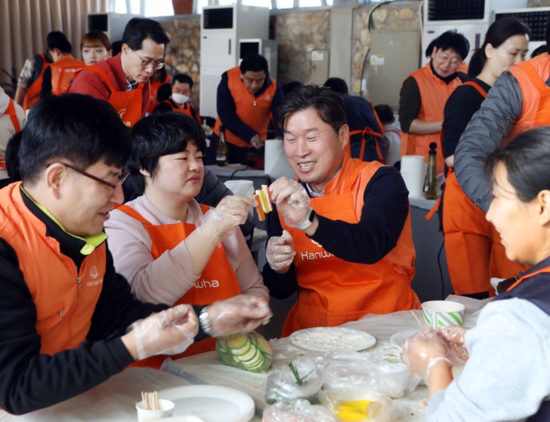 '한화그룹 2020 신임 임원 봉사활동'에 참여한 임원들이 발달장애인들과 함께 설 명절 음식을 만들고 있다.