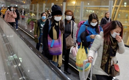 지난 25일 중국 베이징 공항에 도착한 여행객들이 마스크를 쓴 채 에스컬레이터를 타고 이동하고 있다.ⓒ연합