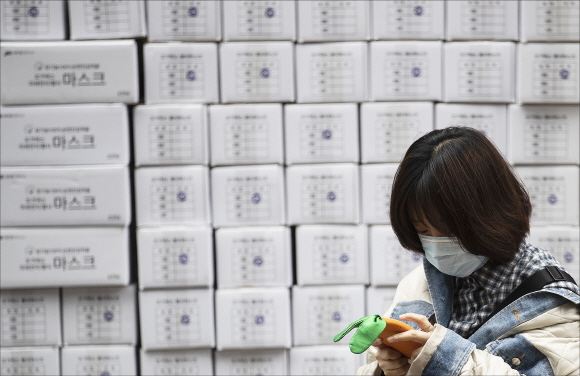 신종 코로나 바이러스 감염증(우한 폐렴)의 확산으로 국내에서도 확진 환자가 발생한 가운데 28일 오후 서울 명동의 한 약국 앞에서 마스크를 착용한 관광객의 너머로 마스크 제품 박스가 쌓여 있다.ⓒ데일리안 홍금표 기자

