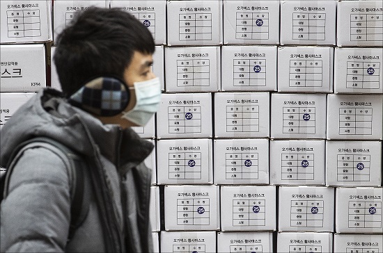 28일 오후 서울 명동의 한 약국 앞에서 마스크를 착용한 관광객의 너머로 마스크 제품 박스가 쌓여 있다. ⓒ데일리안