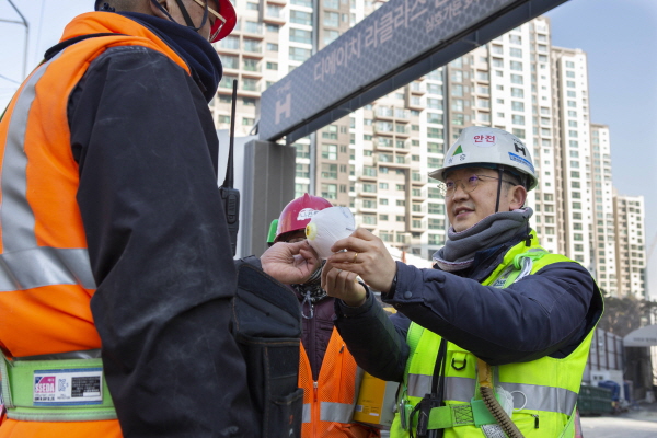 현대건설 관계자가 현장 근로자에게 마스크를 전달하고 있다. ⓒ현대건설