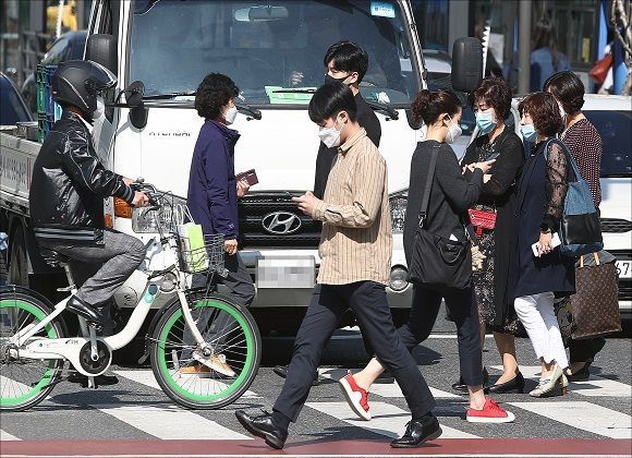 코로나19 감염 예방을 위한 사회적 거리두기가 종료되고 생활 속 거리두기가 시작된 6일 오전 서울 종로구 광화문네거리에서 황금연휴를 마친 시민들이 길을 지나고 있다