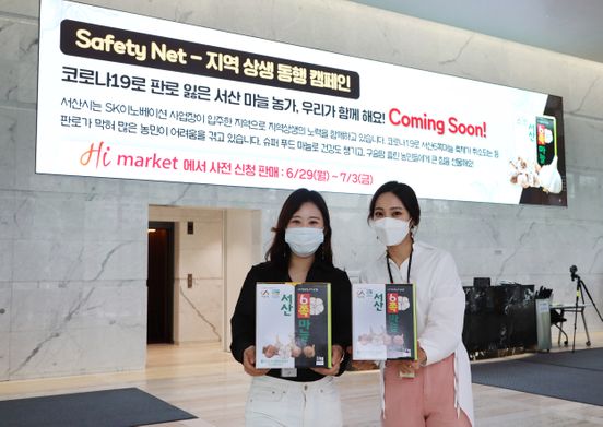 SK이노베이션 직원들이 서울 종로구SK서린빌딩 로비의 대형 사이니지에 뜬 사회안전망 구축 캠페인 내용을 살펴보고 있다.ⓒSK이노베이션