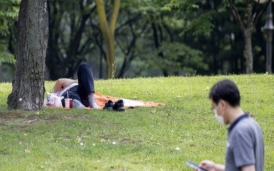 지난 2일 오후 서울 여의도공원에서 한 시민이 점심시간에 그늘에서 휴식을 취하고 있다.ⓒ연합뉴스