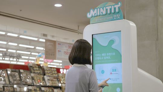 중고폰 거래기기인 ‘민팃ATM’이용 고객이 기부한 중고폰이 1만대를 돌파했다. 사진은 고객이 민팃ATM을 이용해 중고폰 평가액을 기부하고 있는 모습.ⓒSK네트웍스