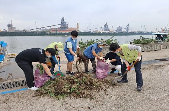 포항제철소 임직원들이 지난 5일 태풍피해를 입은 자매마을을 위해 해도동 형산강 둔치에서 쓰레기를 치우고 있다.ⓒ포항제철소