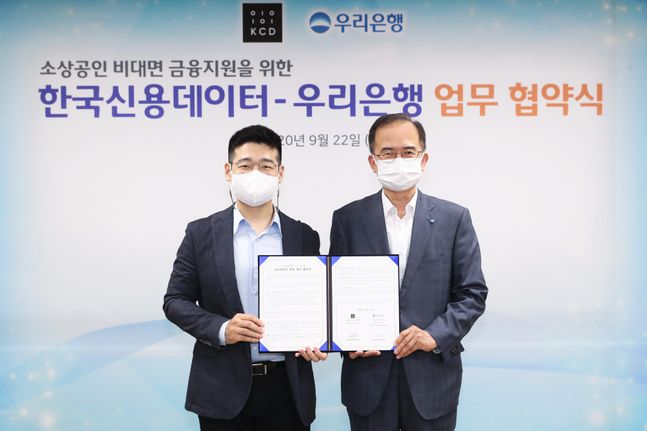 서동립(사진 오른쪽)우리은행 중소기업그룹장과 김동호(사진 왼쪽)한국신용데이터 대표이사가 기념촬영을 하고 있다.ⓒ우리은행