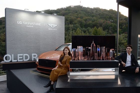 모델들이 서울 중구 반얀트리 클럽 앤 스파 서울 호텔에 전시된 LG 시그니처 올레드 R와 벤틀리 컨티넨탈 GT 차량 앞에서 포즈를 취하고 있다.ⓒLG전자