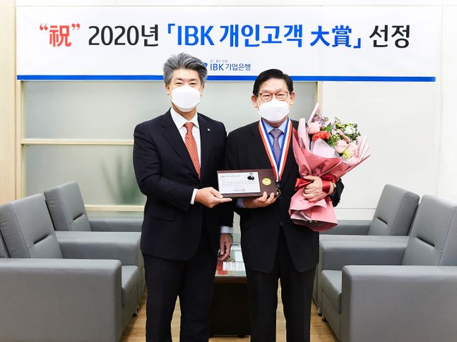 지난 30일 기업은행 강남지역본부 회의실에서 윤종원 IBK기업은행장과 이홍근 고객이 감사패를 들고 기념촬영을 하고 있다.ⓒIBK기업은행