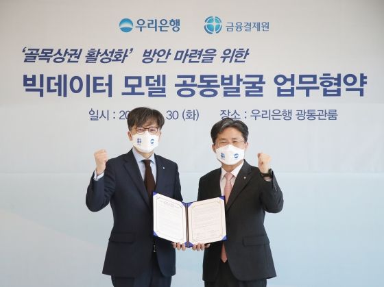 우리은행은 30일 서울 중구 본점 광통관에서 금융결제원과 '골목상권 활성화 방안 마련을 위한 빅데이터 모델 공동발굴 업무협약'을 맺었다. 우리은행 DT추진단 황원철(왼쪽)부행장과 금융결제원 e사업본부 권영식(오른쪽)본부장이 기념촬영을 하고 있다.ⓒ우리은행