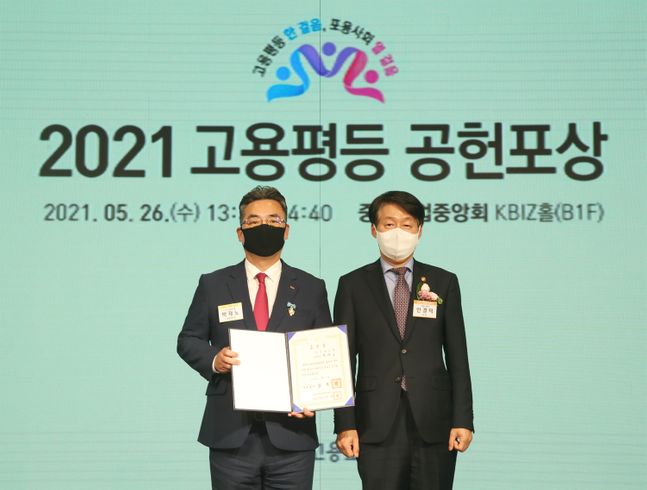 BNK경남은행 박재노 센터장(사진 왼쪽)이 중소기업중앙회 KBIZ홀에서 열린 2021 고용평등 공헌포상 시상식에서 고용노동부 안경덕 장관으로부터 국무총리상을 수상하고 있다. ⓒBNK경남은행