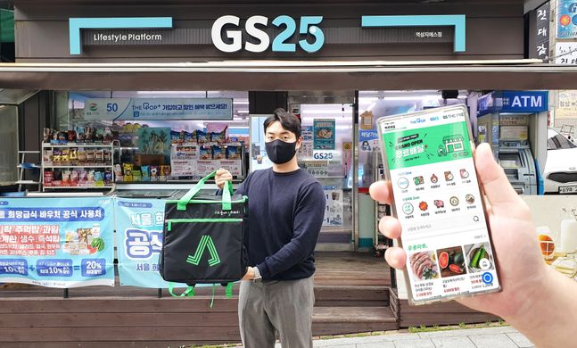 GS리테일이 지난달 22일 론칭한 '우딜-주문하기' 배달자가 GS25 매장 앞에서 주문 상품을 들어보이고 있다. ⓒGS리테일