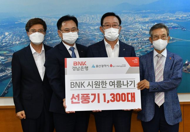 BNK경남은행 이상봉 상무(사진 왼쪽 두번째)가 울산광역시 송철호 시장(사진 오른쪽 두번째)과 울산사회복지공동모금회 한시준 회장(사진 오른쪽 첫번째)에게‘BNK시원한 여름나기 선풍기 기탁 증서’를 전달하고 있다.ⓒBNK경남은행