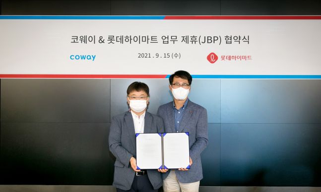 코웨이 이지훈 2사업본부장(왼쪽)과 롯데하이마트 맹중오 상품본부장이 서울 구로구 지타워에서 진행된 업무 제휴 협약식에서 기념 촬영을 하고 있다.ⓒ코웨이