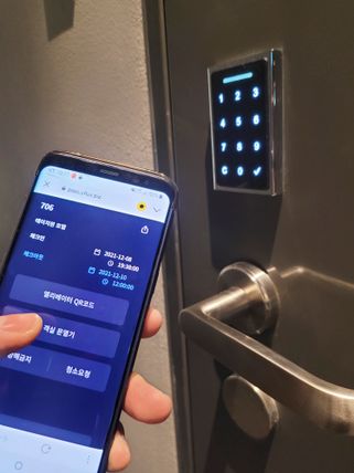 스마트 객실관리 시스템으로 객실 출입문을 개폐하는 모습.ⓒKT