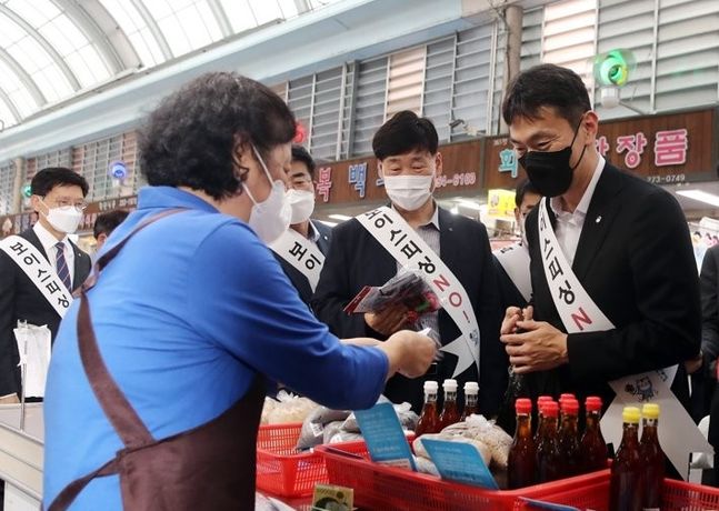 사진은 금융감독원의 '우리은행 횡령사고에 대한 검사결과' 발표가 있던 달일(26일) 이복현 금융감독원장이 전북 전주시 완산구 신중앙시장을 방문해 소상공인의 애로사항을 듣고 참기름을 구입하고 있는 모습.ⓒ연합